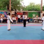Les deux athlètes se préparent pour démarrer la finale kumite open hommes dirige par sensei Metu(entre les deux athlètes) le formateur des arbitres