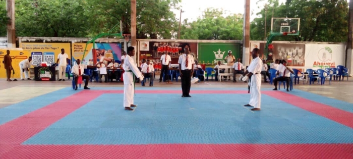 Les deux athlètes se préparent pour démarrer la finale kumite open hommes dirige par sensei Metu(entre les deux athlètes) le formateur des arbitres
