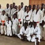 Vue d'ensemble de la délégation de la FTK, des stagiaires et du secrétaire général de la préfecture de Cinkasse en tenue traditionnelle