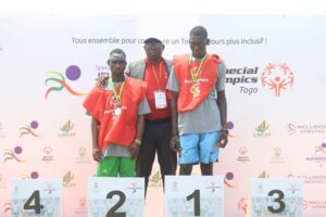 Photo du podium 50 m marche hommes avec le directeur national du conseil d’administration de Special Olympics Togo Gneny Tchagbele